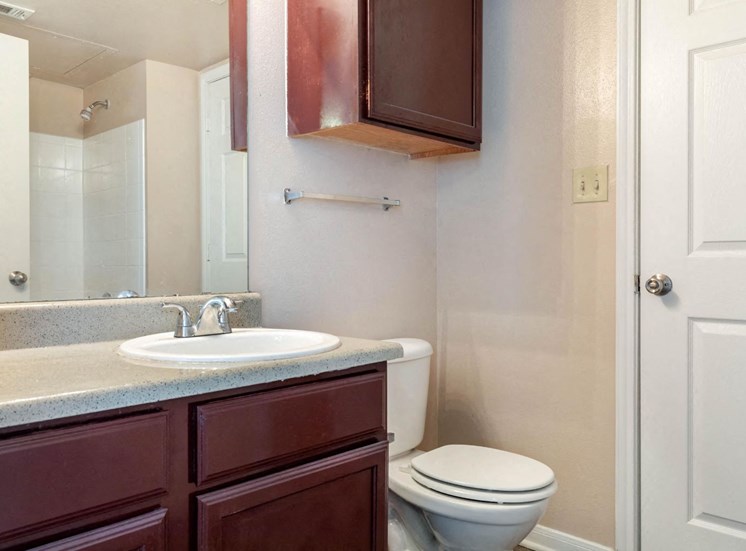 Bathroom with wooden cabinetry and towel bar behind toilet
